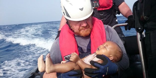 German rescuer from the humanitarian organisation Sea-Watch holds a drowned migrant baby, off the Libyan cost May 27, 2016. The baby, who appears to be no more than a year old, was pulled from the sea after a wooden boat capsized last Friday. (Christian Buettner/Eikon Nord GmbH Germany/Handout via REUTERS)