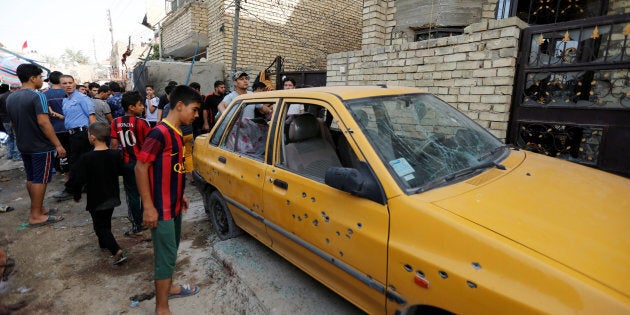 People gather at the site of a suicide bomb attack in the city's northern al-Shaab district in Baghdad, Iraq October 15, 2016. REUTERS/Ahmed Saad