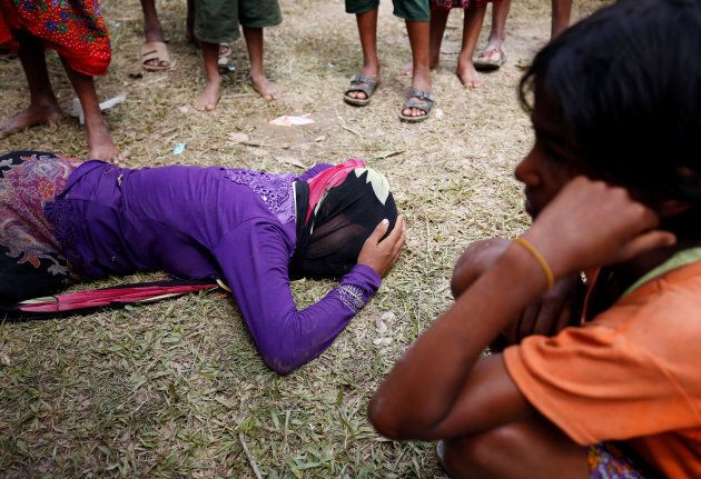 A Rohingya woman cries on the ground, as she received news, over the phone, that her husband was killed by the Myanmar Army, in Cox's Bazar, Bangladesh August 28, 2017.