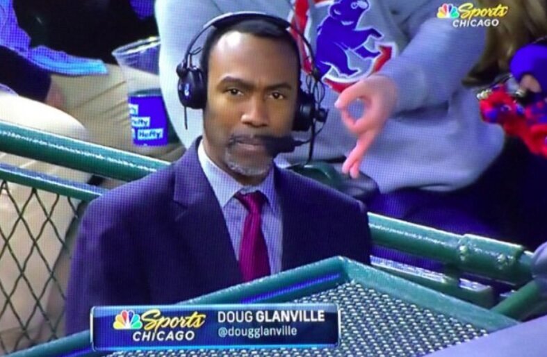 A fan in a gray sweatshirt flashes an alleged white power symbol behind NBC Sports Chicago reporter and former MLB player Doug Glanville. (Twitter/@Flipkin)