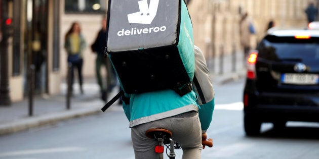 A cyclist rides a bicyle as he delivers food for Deliveroo.