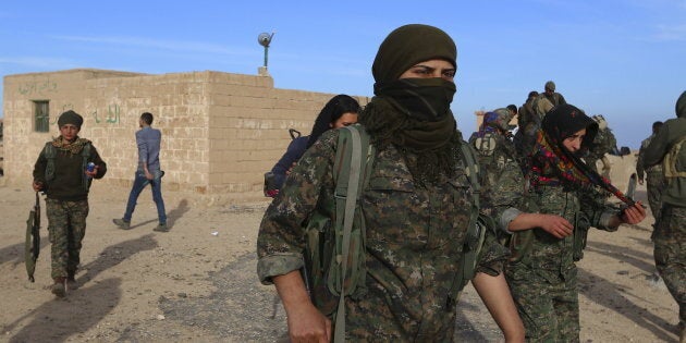 Fighters from the Democratic Forces of Syria carry their weapons in Ghazila village after taking control of the town from Islamic State forces in the southern countryside of Hasaka, Syria February 17, 2016. Picture taken February 17, 2016. REUTERS/Rodi Said