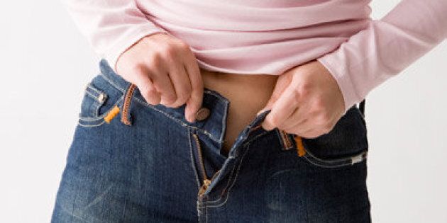 Mid adult woman putting on jeans. Keywords: People, Casual Clothing, Jeans, Horizontal, Studio Shot, Midsection, 35-39 Years, Waist, Japanese Ethnicity, Overweight, Standing, Applying, One Person, Adult, Mid Adult, Color Image, Dieting, One Mid Adult Woman Only, Only Women, One Woman Only, Photography, Too Small, Buttoning, White Background, Adults Only, Only Japanese, Tight.