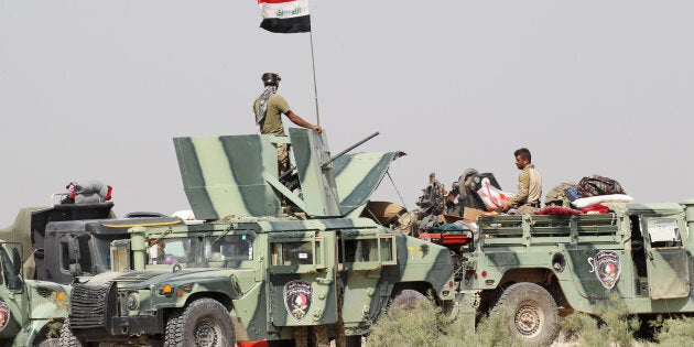 Iraqi security forces sit in military vehicles in the Nuaimiya suburb of Fallujah, Iraq, June 1, 2016. REUTERS/Alaa Al-Marjani