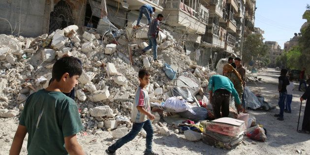 People remove belongings from a damaged site after an air strike Sunday in the rebel-held besieged al-Qaterji neighbourhood of Aleppo, Syria October 17, 2016. REUTERS/Abdalrhman Ismail