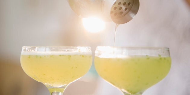 Pacific Islander woman pouring cocktails from shaker