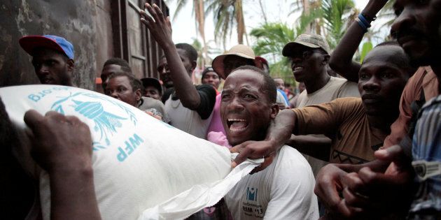 Haitians fight over a sack of rice distributed by humanitarian aid workers after Hurricane Matthew ripped through the tiny nation.