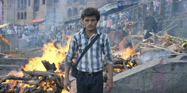 'Nadi the death photographer' stands afront the burning ghats of Varanasi, India.