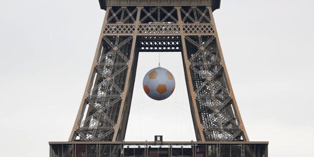 A soccer ball is suspended under the Eiffel Tower before the start of the UEFA 2016 European Championship in Paris, France, June 3, 2016. REUTERS/Charles Platiau