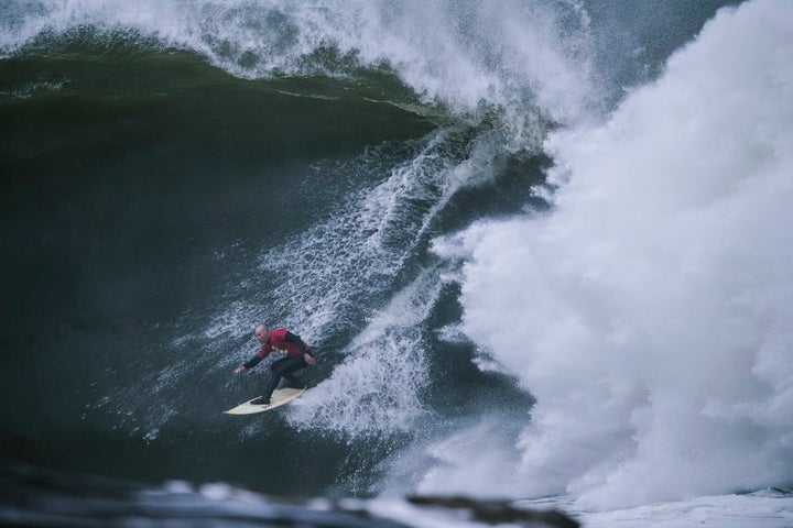 Justen Allport is dwarfed by a wave.