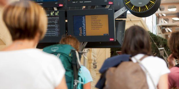 Passengers look at information monitors as they wait for their trains at The Saint-Charles Station in Marseille on August 20.