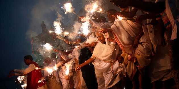 Widows light sparklers after offering prayers as part of Diwali celebrations.
