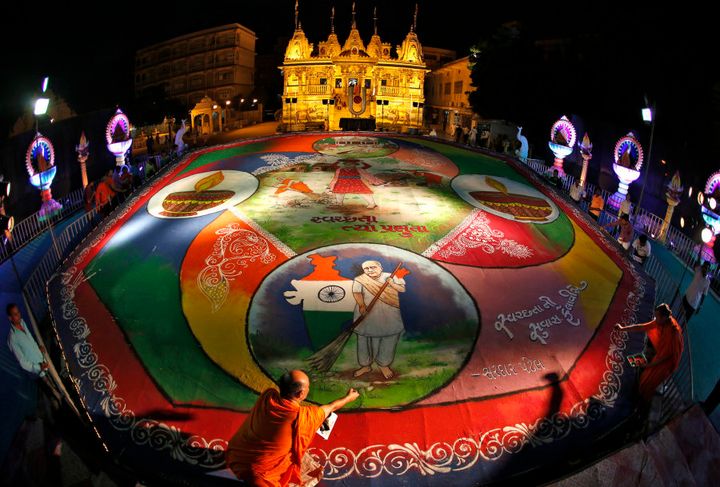 Hindu priests put the finishing touches to a rangoli artwork in the western Indian city of Ahmedabad.