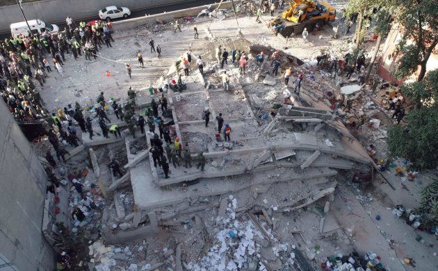 Rescuers look for survivors in a multistory building flattened by a powerful quake in Mexico City.