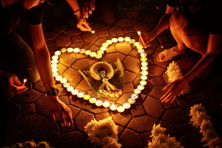 Mourners light up candles outside of the Grand Palace to pay respects to the King.