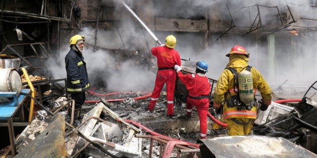 Firemen hose down a burning building at the site of car bomb attack in Baghdad al-Jadeeda, an eastern district of the Iraqi capital.