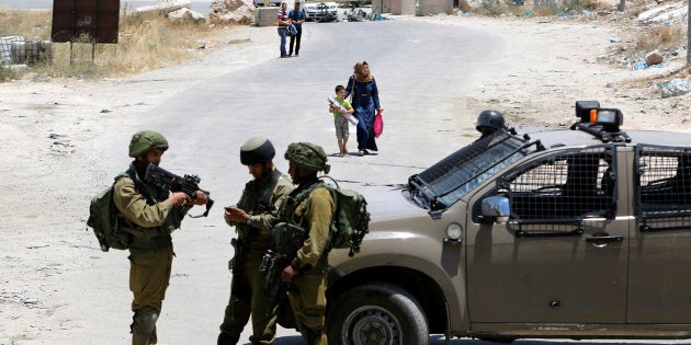 Israeli soldiers stand guard at the entrance of Yatta near the West Bank city of Hebron.