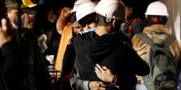 Workers hug during the search for students at Enrique Rebsamen school.