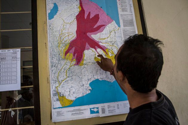 A man looks a map of the danger zones at the Mount Agung monitoring station in the Karangasem regency of Bali.