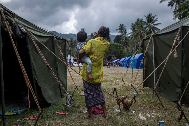 An elderly woman carries a baby in an evacuation centre for more than 35,000 villagers forced to flea nearby areas of Mount Agung.