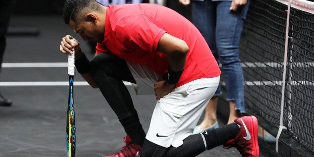 Nick Kyrgios drops to one knee before his match against Roger Federer.