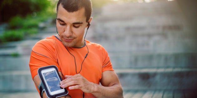 Man using smart phone armband while standing at steps