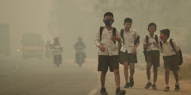 Students walk along a hazy street in Jambi, Indonesia, on Sept. 29, 2015. The World Meteorological Organization reported Monday that carbon concentrations surpassed 400 parts per million last year for the first time.