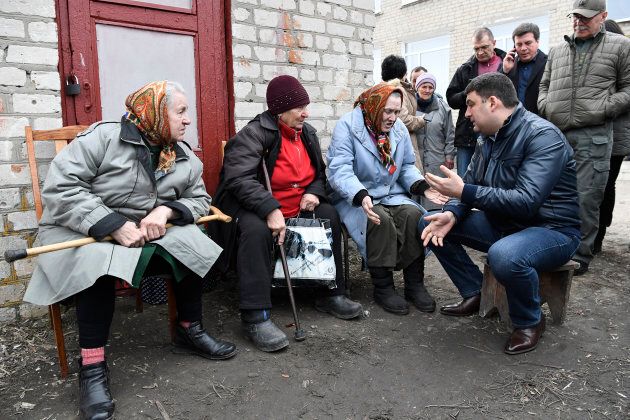 Ukrainian Prime Minister Volodymyr Groysman meets with local residents at a collection point for evacuees.