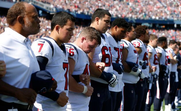 The Houston Texans stand and link arms during the national anthem before the game against the New England Patriots.