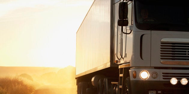 Semi-truck driving on dusty dirt road