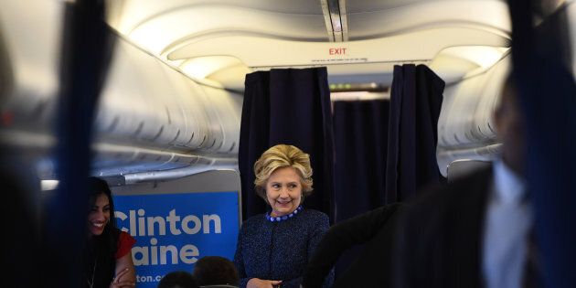 US Democratic presidential nominee Hillary Clinton talks to staff onboard her campaign plane at the Westchester County Airport in White Plains, New York, on October 28, 2016. / AFP / Jewel SAMAD (Photo credit should read JEWEL SAMAD/AFP/Getty Images)