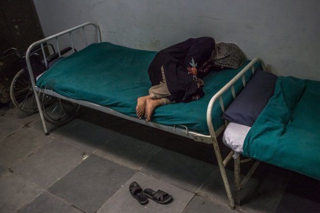 In this photo taken on November 20, 2015, Kashmiri patient Masrat Naz, 45, and who is suffering from symptoms of schizophrenia, lies on a bed as she periodically shouts to medical staff after being brought by relatives to the casualty ward at the Psychiatric Diseases hospital in Srinagar.