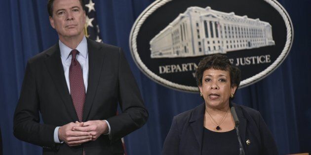 FBI Director James Comey, left, stands alongside Attorney General Loretta Lynch during a press conference at the Department of Justice on March 24, 2016.