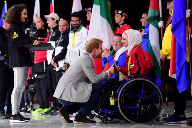 Prince Harry shakes hands with flag bearer Ulfat Al-Zwiri of Jordan during the closing ceremony of the Invictus Games.