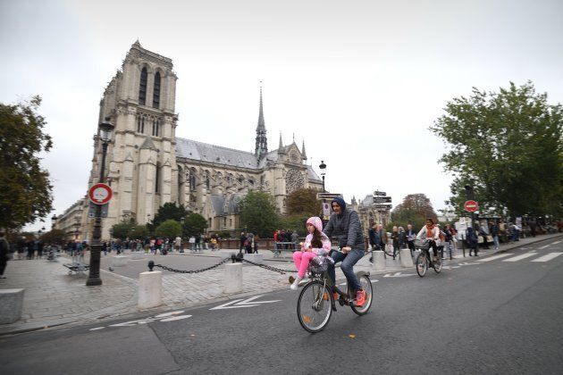 A cyclist rides past Notre Dame Cathedral.