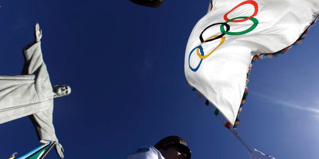 Municipal Guards hold up the Olympic Flag in front of