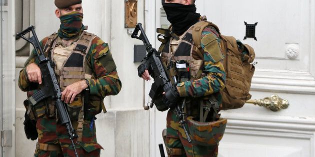 Belgian police arrested 12 suspects in a major anti-terror operation overnight. Above, Belgian soldiers stand guard outside the prime minister's office.