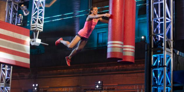An American Ninja Warrior contestant jumps and hopes.
