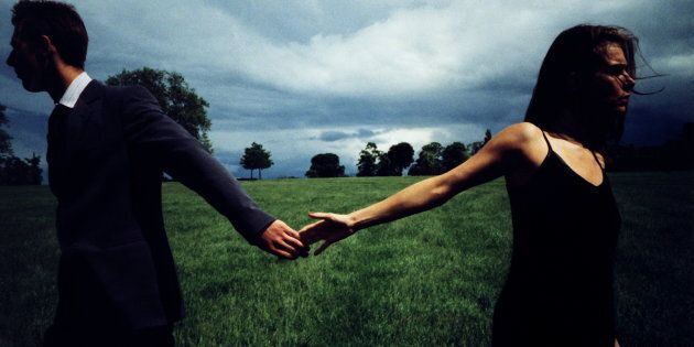 Couple in field, letting go of each other's hands