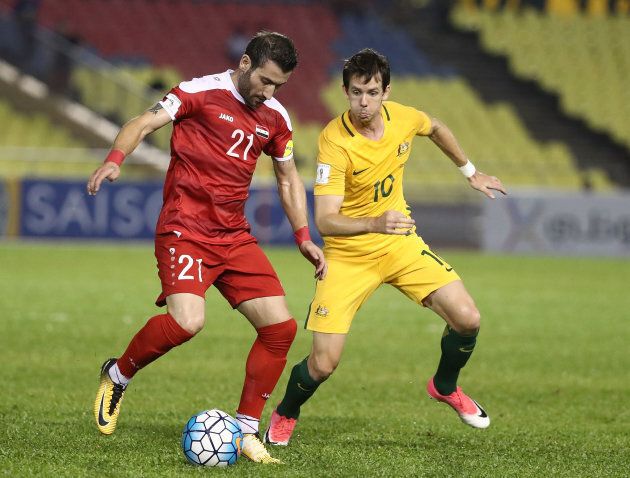 Faced Youssef of Syria is pressured by Robbie Kruse during the 2018 FIFA World Cup Asian Playoff.