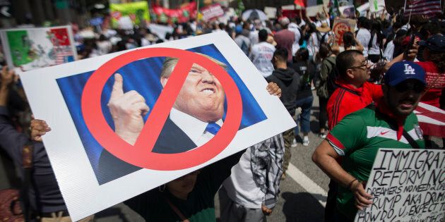LOS ANGELES, CALIFORNIA - MAY 1: A woman carries a placard critical of Republican presidential candidate Donald Trump during one of several May Day marches on May 1, 2016 in Los Angeles, California. Immigrants, union members, workers and supporters are participating in the annual marches in downtown Los Angeles to call for greater rights for immigrants and improved conditions for workers. (Photo by David McNew/Getty Images)