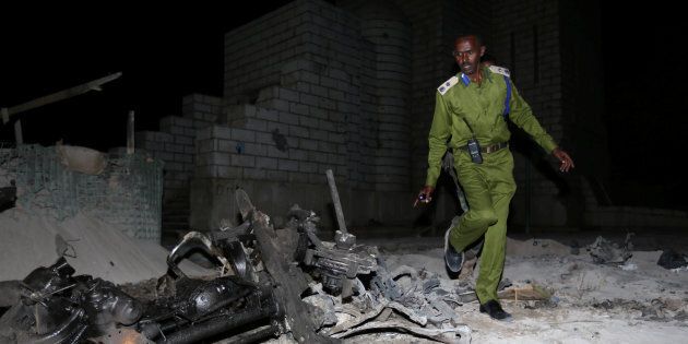A Somali policeman inspects the scene of a suicide car explosion near the parliament in the capital Mogadishu, on Nov. 5, 2016.