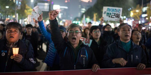 Demonstrators shout slogans during a protest calling for the resignation of South Korean President Park Geun-Hye in central Seoul on November 5, 2016.Thousands of South Koreans took to the streets November 5 to demand embattled President Park Geun-Hye resign over a crippling corruption scandal. / AFP / Ed JONES (Photo credit should read ED JONES/AFP/Getty Images)