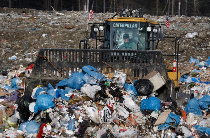 A bulldozer operator plows trash at the town landfill, Wednesday in Bath, Maine.