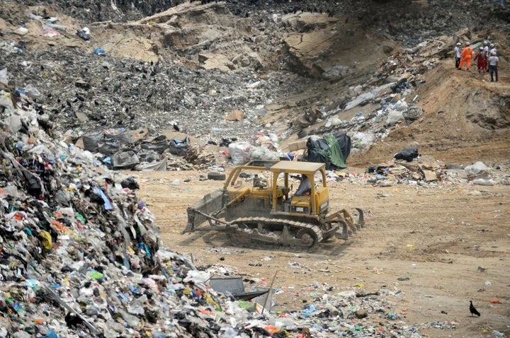 Municipal firemen and rescue workers search for victims at the site of a landslide at a garbage dump in Guatemala City.