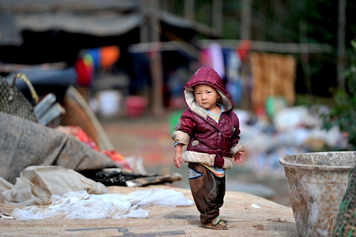 Children play at the China's largest landfill site as their parents look for recyclable items to sell. Some children often help their parents make a living from the landfill site.