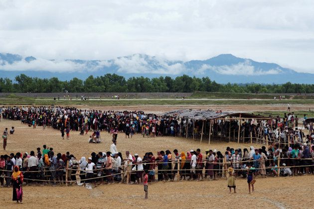 Rohingya refugees line up to receive food at a camp near Teknaf, Bangladesh.