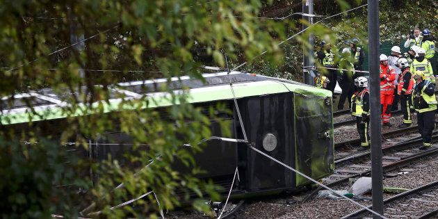 Members of the emergency services work next to a tram after it overturned injuring and trapping some passengers in Croydon, south London, Britain November 9, 2016.