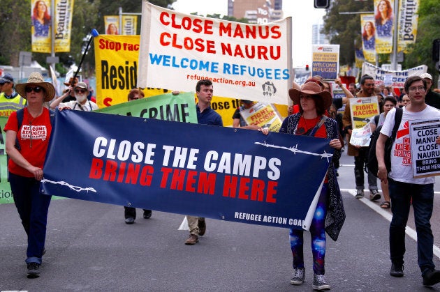 Refugee advocates hold placards as protest against the treatment of asylum-seekers in detention centres, in Sydney on October 15