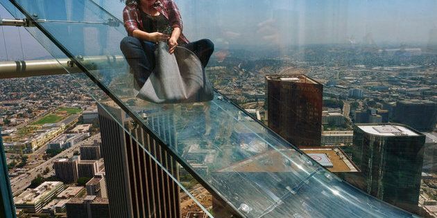 LOS ANGELES, CA - JUNE 25: A guest rides the SkySlide during the OUE Skyspace LA grand opening block party at OUE Skyspace LA on June 25, 2016 in Los Angeles, California. (Photo by Mark Davis/Getty Images for Ogilvy PR)